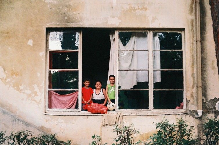 Three children in a weathered window